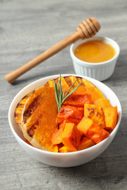istock Baked pumpkin, honey and dipper on gray textured background 1495139548
