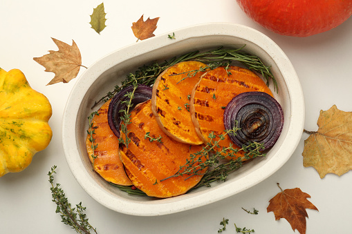 Autumn concept with baked pumpkin on white background.