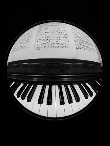 Black and white photo of a piano and the music sheet notes