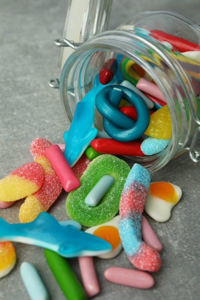 istock Jar with gummy candies on gray textured background 1495143855