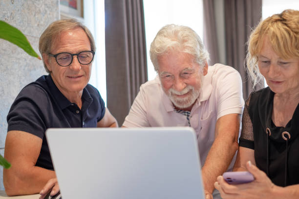 istock Group of mature confident business people analyzing data using together laptop computer and smartphone while spending time working from home 1495146614