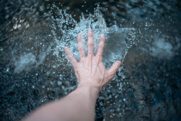 istock male hand playing with water and making drops 1495146691