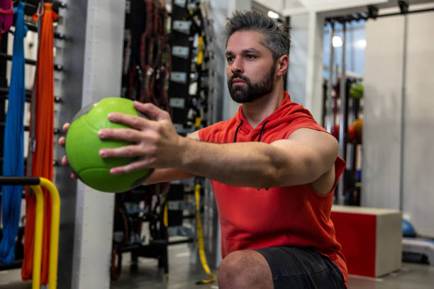 istock Muscular man doing lunges with med ball in gym gym 1495146832
