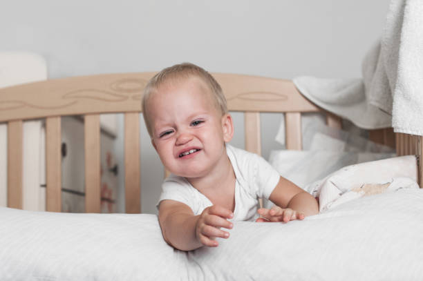 istock Toddler boy crying on bed close-up. 1495149532