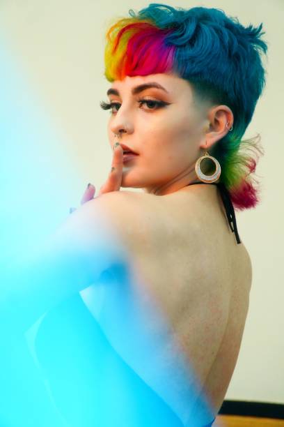 istock Female professional model with vibrant multi-colored hair is striking a confident pose for camera 1495150601