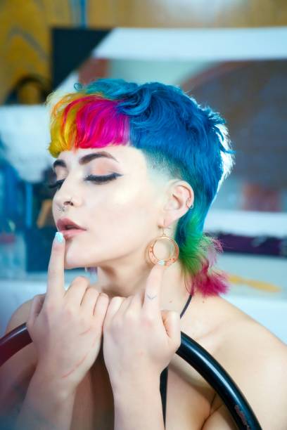 istock Female professional model with vibrant multi-colored hair is striking a confident pose for camera 1495150617