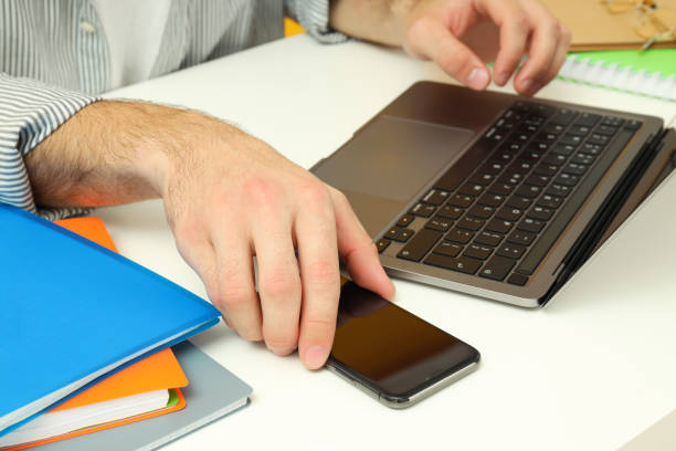 istock Workplace concept with male hands and accessories on white table 1495150900