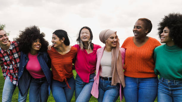 Happy young multi ethnic women having fun in a park - Diversity and friendship concept stock photo