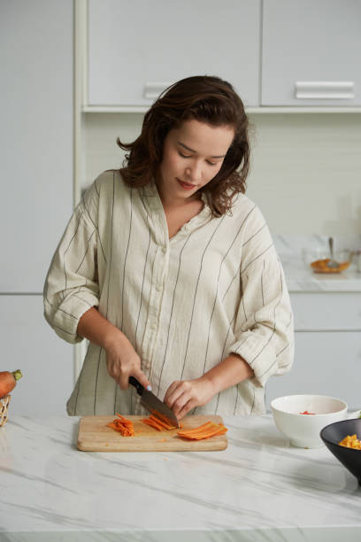 istock Woman Cutting Carrots into Matchsticks 1495156290