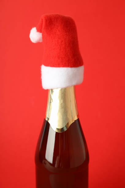istock Champagne bottle with Santa hat on red background 1495156843