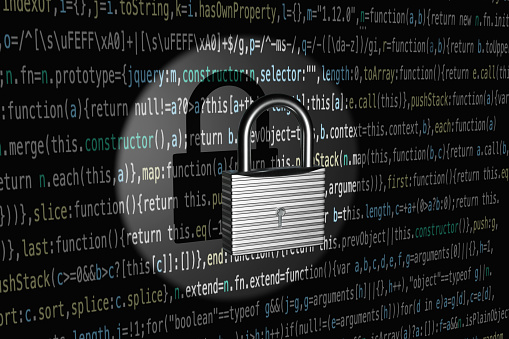 Vintage silver lock highlighted by a spotlight and projected a shadow on computer source codes. Illustration of the concept of security and safety of computer programming source codes