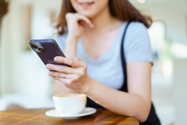 istock Woman drinking coffee and using smartphone in coffee shop. 1495158779