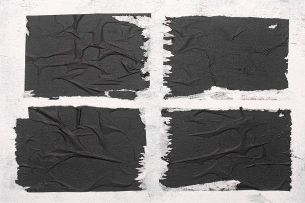 istock Four black sheets with folds on the wall. 1495161302