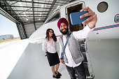 Man Wearing Vest Clicks Selfie With Air Hostess on Steps of Private Jet
