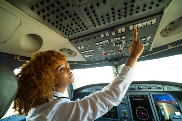 istock Pilot With Curly Hair Pressing Buttons In a Plane Cockpit 1495164594