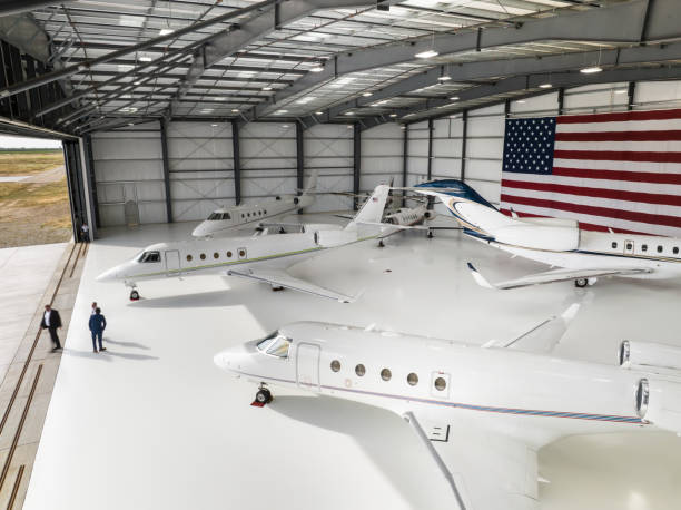 High Angle View of Fleet of Private Jets Inside Hangar Five private planes parked inside a massive hangar bearing the United States flag.
This drone shot was taken with full permission and co-operation of the airport staff and the pilots of the aircraft. airplane hangar stock pictures, royalty-free photos & images