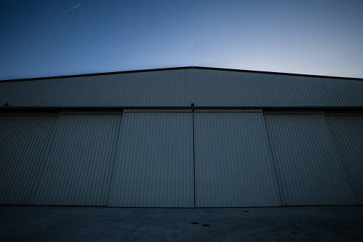 A still image of an airplane hangar during sunset.