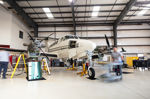 A turboprop plane undergoing maintenance inside the hangar of a small general aviation airport in California.