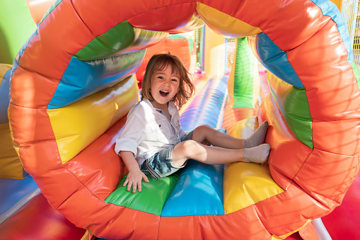 Cute little kid having fun in inflatable castle playground