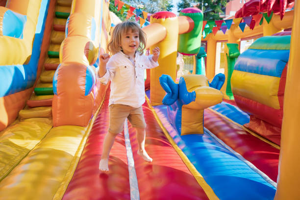 Happy little kid having fun in inflatable castle playground.