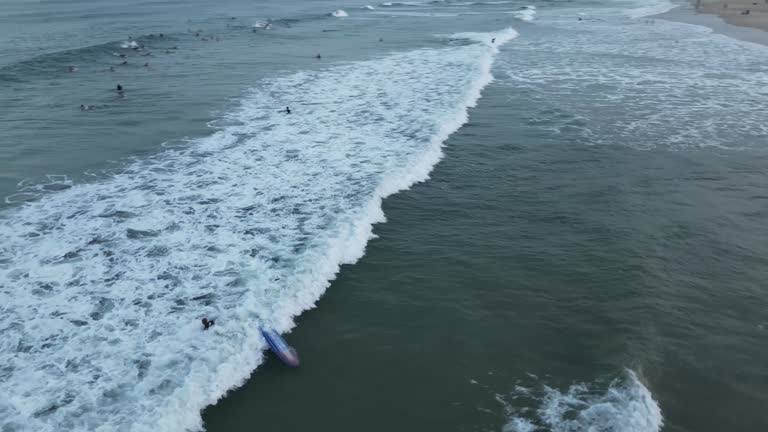 black man surfing at beach sunset