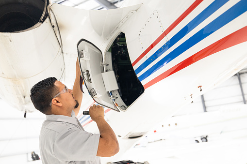 an aircraft mechanic is servicing the plane in the workshop