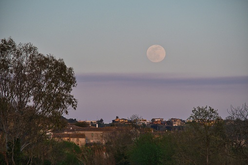 The moon rises over the town