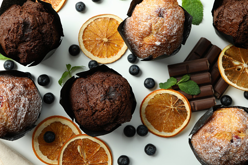 Concept of delicious food with chocolate muffins on white background.