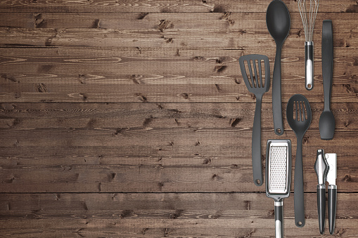Kitchen utensils on a rustic wood background