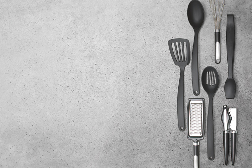Kitchen utensils on a cement stone background