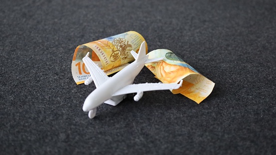 rolled swiss banknotes and a white plane on the table