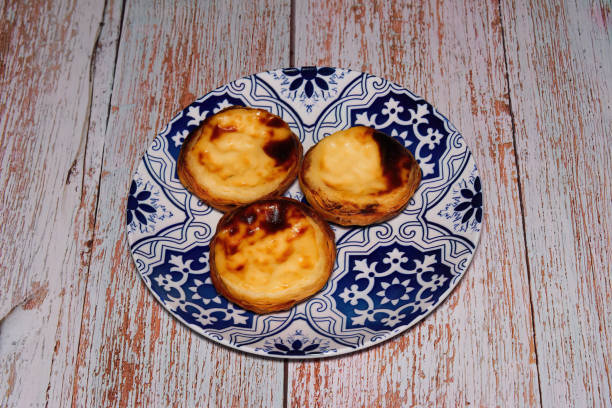 Pasteis De Nata, Pastel de Belem, traditional Portuguese miniature egg custard pastry cakes served on a dish. stock photo