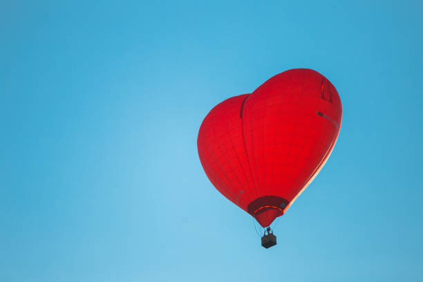 istock A bright red heart-shaped balloon in the sky 1495182588