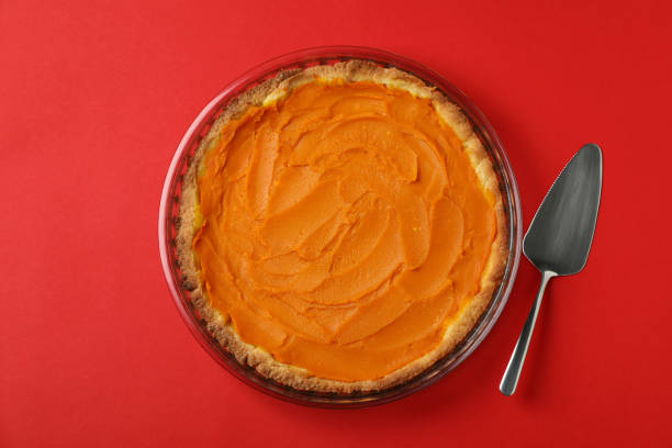 istock Pumpkin pie and cake spatula on red background 1495184578