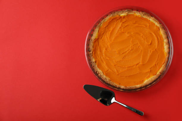 istock Pumpkin pie and cake spatula on red background 1495185745