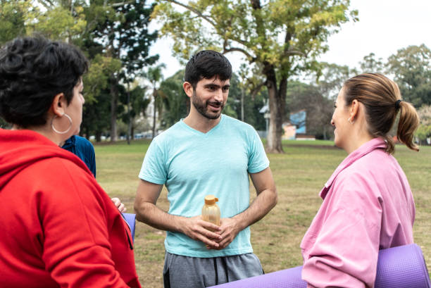 istock Mid adult friends talking at public park 1495187372