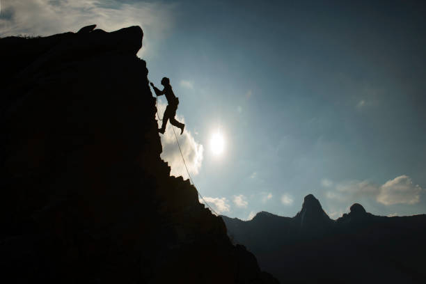 istock silhouette of rock climber rope climbing 1495187744