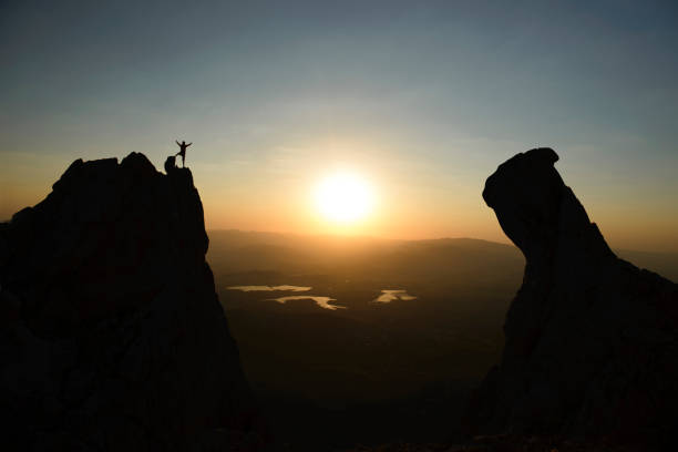 istock summit activity of mountaineer on jagged cliffs at sunrise 1495187767