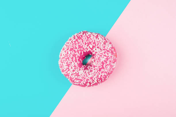 istock Pink donut on color background, flat lay, top view 1495189854