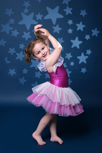 little child girl dreams of becoming  ballerina in a pink tutu skirt