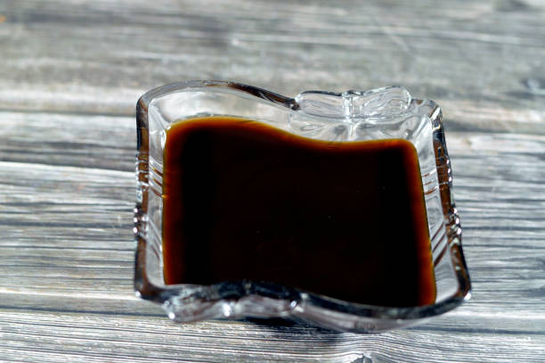 Molasses, a viscous substance resulting from refining sugarcane or sugar beets into sugar, Molasses varies in the amount of sugar, primarily used to sweeten and flavor foods and brown sugar making, selective focus melaza, una sustancia viscosa resultante de refinar la caña de azúcar o la remolacha azucarera en azúcar, la melaza varía en la cantidad de azúcar, utilizada principalmente para endulzar y dar sabor a los alimentos y la fabricación de azúcar morena.