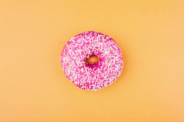 istock Pink donut on color background, flat lay, top view 1495191460