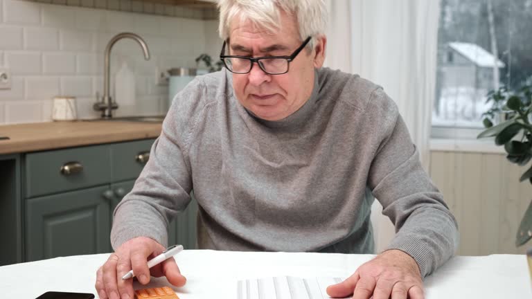 Senior Man Checking Calculating Personal Finance at Home, Feeling Stress from Money Problem. Concerned Elderly Male get Official Bank Notification, Financial Bill, Unpaid Debt or Tax and Feel Worried