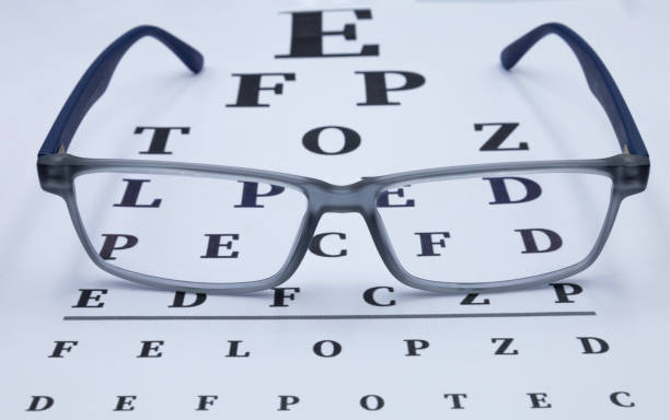 istock Eyeglasses with eye test table. Optical store, glasses selection, eye test, vision examination at optician 1495194340