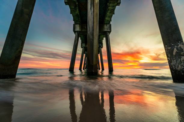istock a pier bridge spans the water below it at sunrise time 1495196545