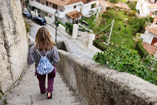 Teenage girl enjoying overcast spring day in Calabrian town of Tropea. She is walking down the stairs from the town on the cliff to the bottom of the cliff (Scala Dei Carabinieri)
Springtime, off-season day in Tropea, Catania, Italy.
Shot with Canon R5