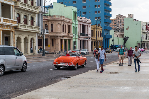 Havana, Cuba - October 21, 2017: Malecon Avenue in Havana, Cuba. People walking, Old Cars in Background