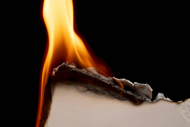 istock burning paper, glowing edge of paper on a black background 1495201701