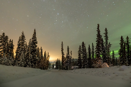 Incredible northern lights landscape in Yukon Territory during winter time with snow covered landscape and Alaska highway in view. Wilderness, arctic area isolated, background, no people, wallpaper, desktop.