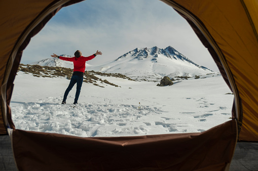 View from inside the tent. Young man camping in the mountain